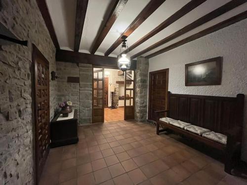 einen Flur mit einer Bank in einem Zimmer mit einer Steinmauer in der Unterkunft Casa Orbara, a 8 Km de Pamplona in Ardanaz