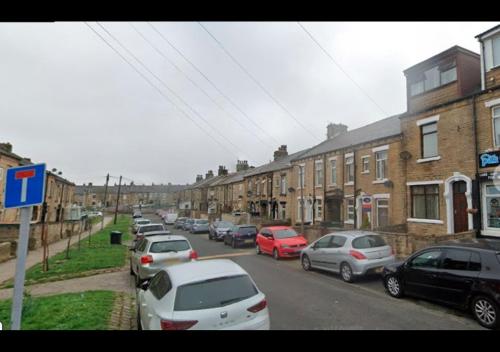 a group of cars parked on a street with buildings at Paradise Apartment- Female Only in Bradford