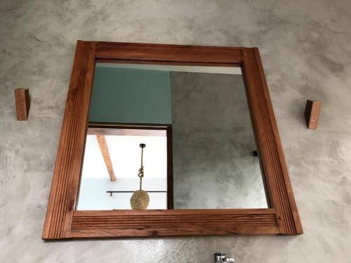 a mirror with a wooden frame on a wall at Baranko Villa in Fort Portal