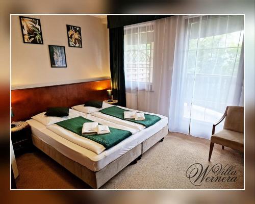 um quarto com uma cama grande e lençóis verdes em Villa Wernera Hotel & Spa em Szklarska Poręba