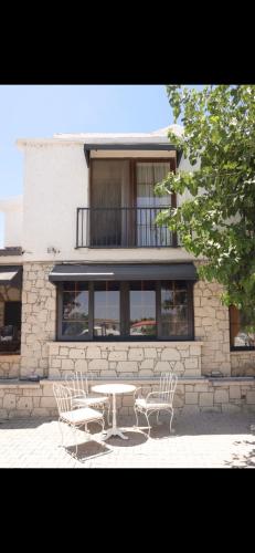 a table and chairs in front of a building at Lion Otel Alaçatı in Alacati