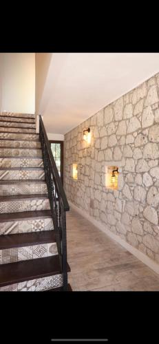 a staircase in a building with a stone wall at Lion Otel Alaçatı in Alacati