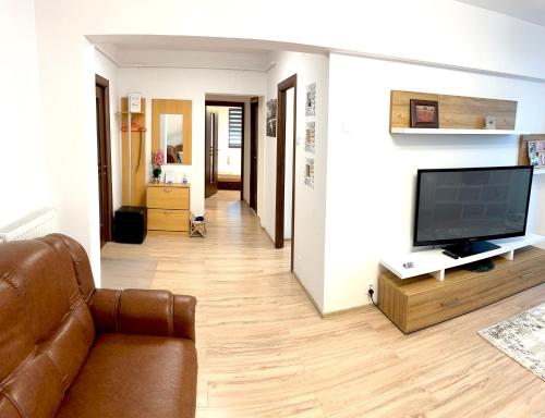 CRISTAL Home Boutique Apartment 1 - Confort, Spatios, Linistit, Zona de interes في كرايوفا: غرفة معيشة مع أريكة وتلفزيون بشاشة مسطحة