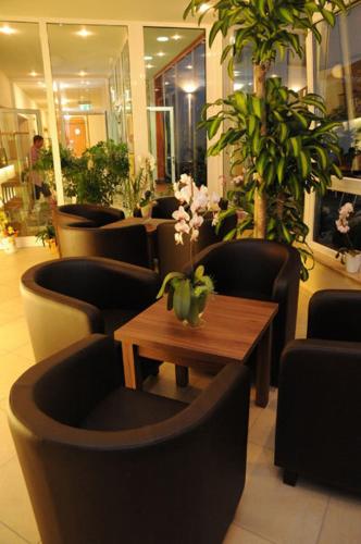 a lobby with chairs and a table with flowers on it at Beierleins Hotel & Catering GMBH in Reichenbach