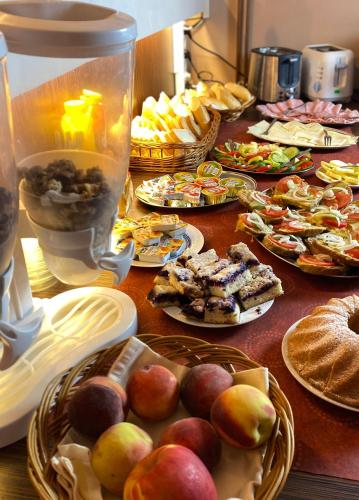 a table with many plates of food on it at Penzion Acrobat Park in Štíty