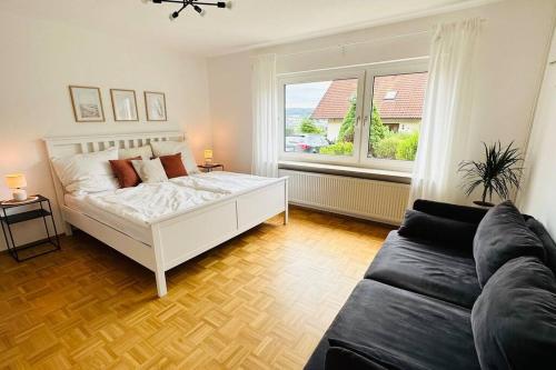 a bedroom with a bed and a couch and a window at Schöne Wohnung "Bethel" in Bad Hersfeld in Bad Hersfeld