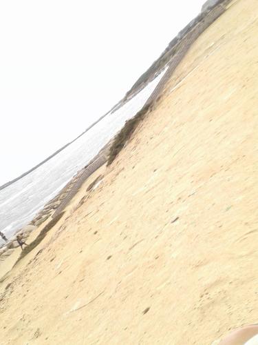 a sandy beach with the ocean in the background at Duplex pied dans l'eau avec magnifique vue sur mer in Monastir