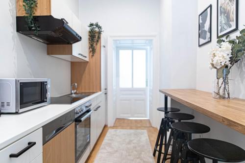 a kitchen with a counter and stools in it at Spacious Apartment, 3 min to U1 Reumannplatz in Vienna