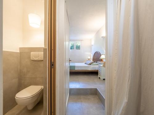 a bathroom with a toilet and a bedroom with a bed at Casa Flaminia Villasimius in Villasimius