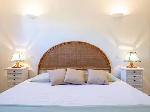 a bedroom with a large white bed with two lamps at Casa Flaminia Villasimius in Villasimius