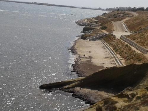 a road on the side of a body of water at Duplex pied dans l'eau avec magnifique vue sur mer in Monastir