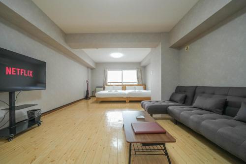 a living room with a couch and a tv at Residence Hotel KABUTO in Sapporo