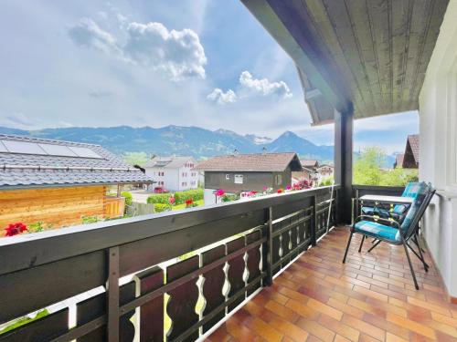 a balcony with a blue chair and a view at Haus Eggensberger in Fischen