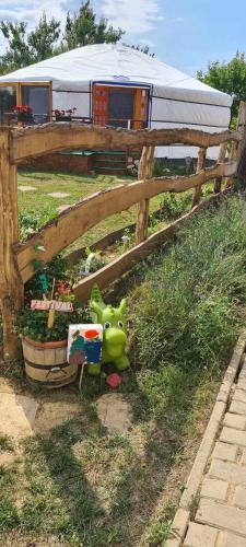 a green toy sitting in the grass next to a fence at Jurtarelax in Kozármisleny