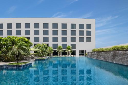 a large swimming pool in front of a building at Novotel New Delhi Aerocity- International Airport in New Delhi