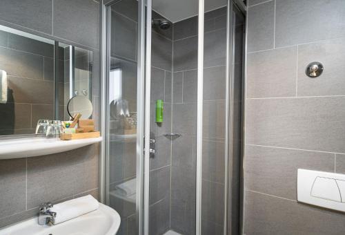 a bathroom with a shower and a toilet and a sink at mainhaus Stadthotel Frankfurt in Frankfurt/Main