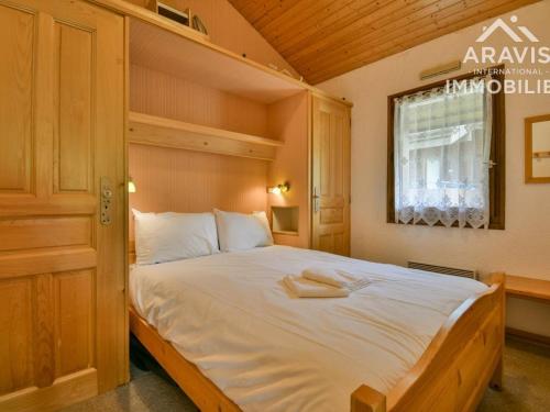 1 dormitorio con 1 cama grande con sábanas blancas y ventana en Appartement Le Grand-Bornand, 4 pièces, 9 personnes - FR-1-391-23, en Le Grand-Bornand