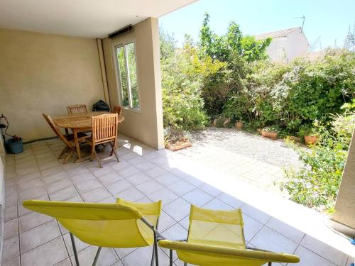 un patio avec une table et des chaises sur un patio dans l'établissement T3 climatisé avec jardin, parking privé, à 400m de la plage et commerces - FR-1-316-230, à Six-Fours-les-Plages