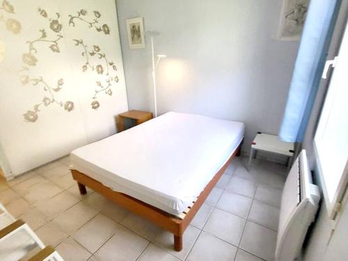 une petite chambre avec un lit et une fenêtre dans l'établissement T3 climatisé avec jardin, parking privé, à 400m de la plage et commerces - FR-1-316-230, à Six-Fours-les-Plages