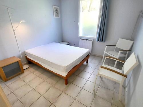 une chambre avec un lit, une télévision et une chaise dans l'établissement T3 climatisé avec jardin, parking privé, à 400m de la plage et commerces - FR-1-316-230, à Six-Fours-les-Plages