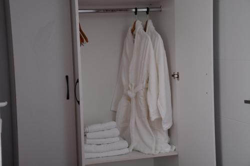 a closet with white towels and a mirror at Pensiunea Maria Mihăești in Mihăeşti
