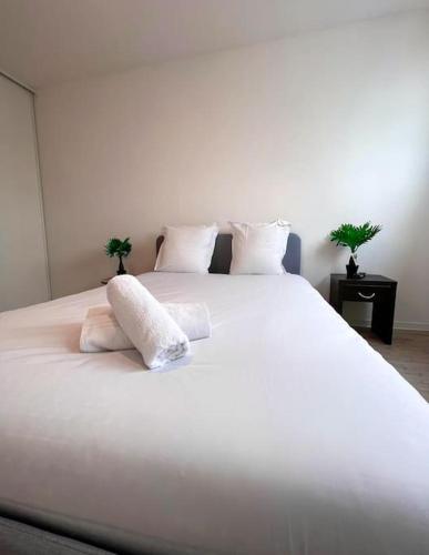 - un grand lit blanc avec 2 oreillers dans l'établissement Disneyland Paris Appartement, à Montévrain