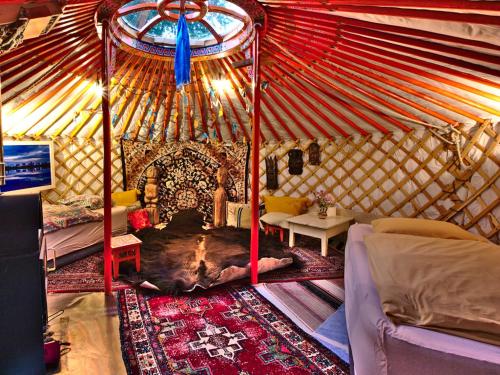 una yurta interior con cama y sala de estar en Jurte in Bayern – spirituelle Reise ins Keltenland, en Neuburg an der Donau