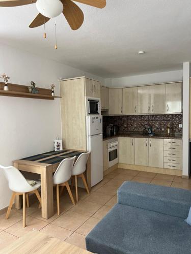 a kitchen with a table and chairs and a couch at Apartamento Soña Club Tenerife Los Cristianos in Los Cristianos