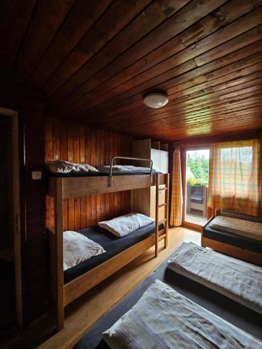a room with two bunk beds in a cabin at Ruška koča in Pohorje