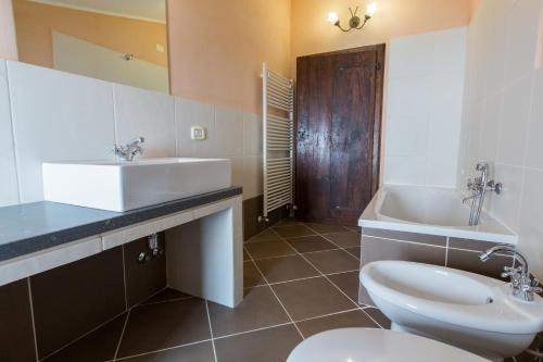 a bathroom with a sink and a toilet and a tub at Borgo Colognola - Dimora Storica in Cenerente