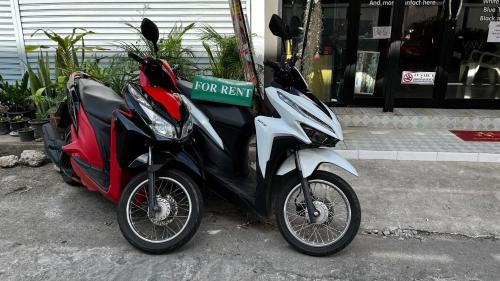 a motor scooter parked on the side of a street at Smile Capsule Hostel in Chiang Mai