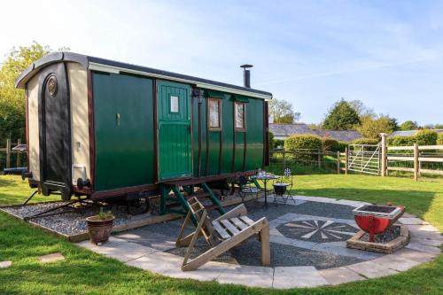 un vagón de tren verde expuesto en un patio en Dotties Retreat en Combe Martin