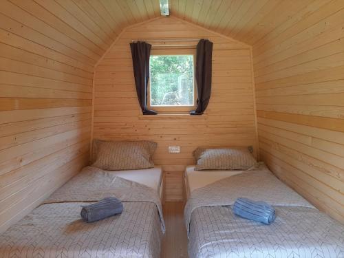 Camping & Glamping Grintovec في بريدفور: غرفة صغيرة بسريرين في كابينة