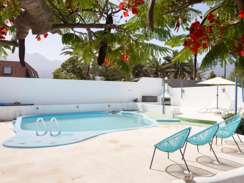 a swimming pool with two chairs and a table at Live Socorro Juan Fu Rural in Güimar