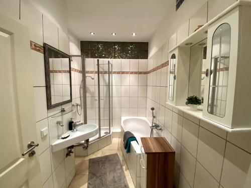 Un baño blanco con dos lavabos y un espejo. en Cosy & central flat near Düsseldorf center, en Düsseldorf