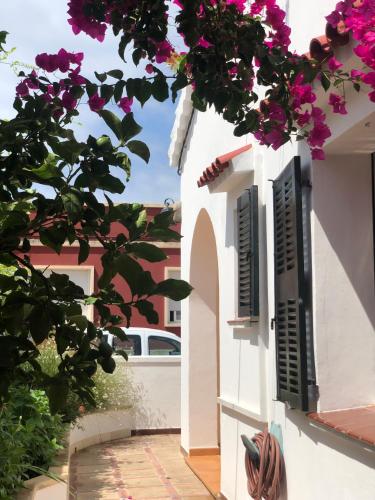 a white house with flowers on the side of it at Casa Típica Ciutadella centro in Ciutadella