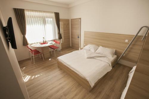 a bedroom with a bed and a table and a window at Sweet Dreams Rooms and Apartments Postojna in Postojna