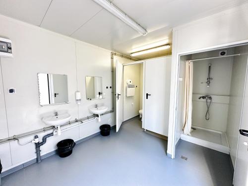 a bathroom with two sinks and two mirrors at Julinek CAMP in Leszno