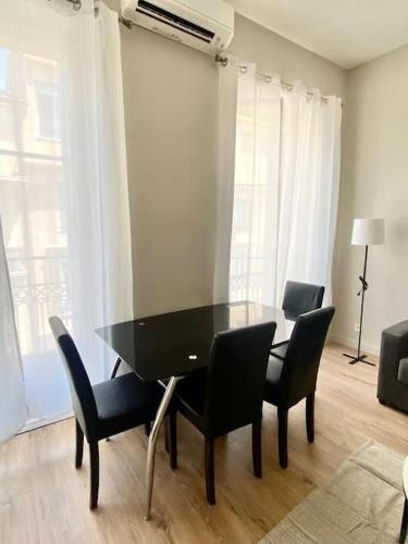 a black dining room table and chairs in a room at Appartement au coeur de Nice pour 4 - Clim & Wifi in Nice