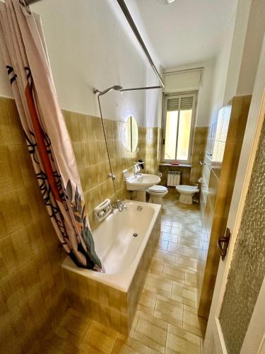 a bathroom with a tub and a toilet and a sink at Casa Vittorio in Turin