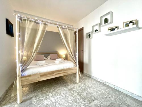 um quarto com uma cama de dossel em Le St Pierre, joli T1 central à 2 minutes des plages em Menton