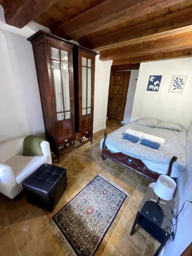 a bedroom with a bed and a couch in a room at Caserío `The Formicary´ in Antezana de la Ribera