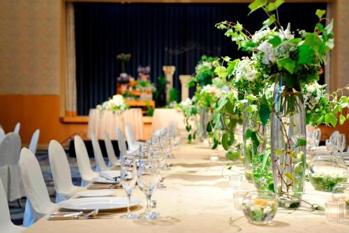 a long table with white chairs and vases with flowers at The Westin Miyako Kyoto in Kyoto