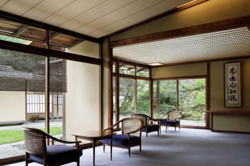a room with tables and chairs and windows at The Westin Miyako Kyoto in Kyoto