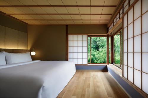 a bedroom with a bed and large windows at The Westin Miyako Kyoto in Kyoto