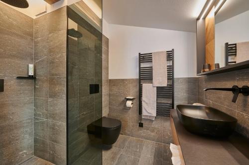 a bathroom with a black sink and a shower at Penthouse Suite by Brugger in Taxenbach