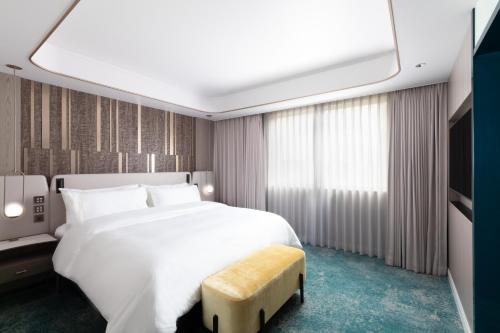 a bedroom with a large white bed and a tv at The Westin Miyako Kyoto in Kyoto