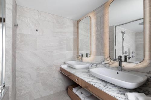 a bathroom with two sinks and a mirror at The Westin Miyako Kyoto in Kyoto