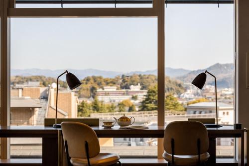 a desk with two chairs and a table with two lamps at The Westin Miyako Kyoto in Kyoto