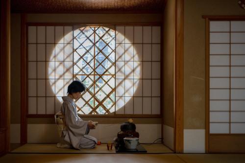 a person sitting on the floor in front of a window at The Westin Miyako Kyoto in Kyoto